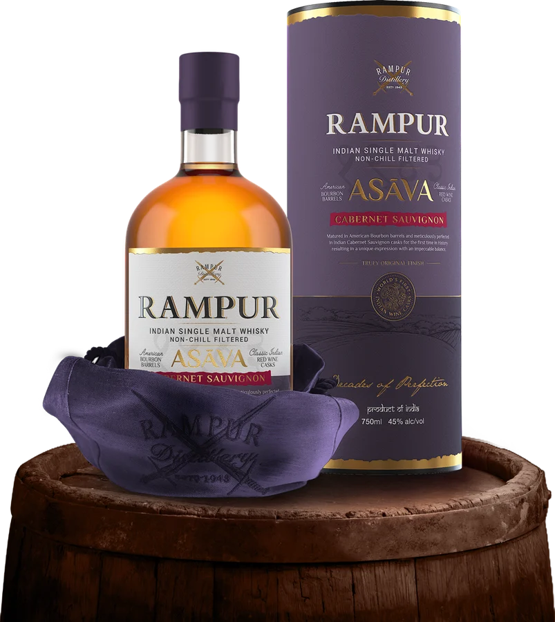 Rampur Asava single malt bottle and tube on a barrel.